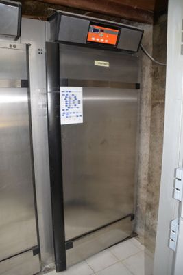 a refrigerator that is in the corner of a room