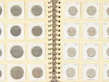 un livre ouvert sur lequel sont posées plusieurs pièces de monnaie différentes