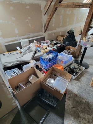 une pièce où il y a beaucoup de boîtes et de cartons sur le sol