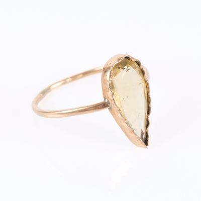 a close up of a gold ring with a white stone in the middle