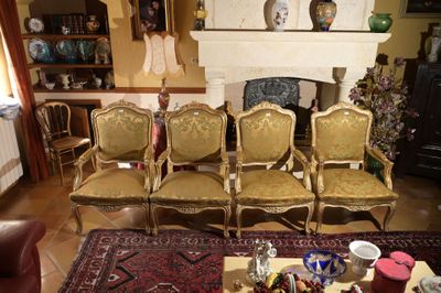 quatre chaises dans un salon avec un tapis au sol