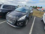Des voitures sont garées sur un parking, avec un ciel nuageux en arrière-plan.