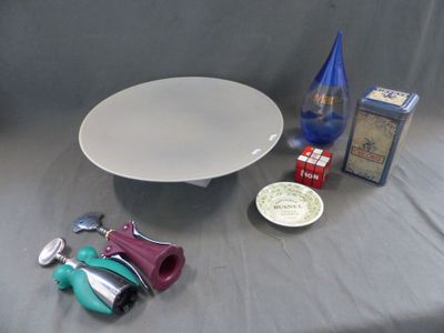 une assiette blanche, une bouteille bleue et d'autres objets posés sur une table