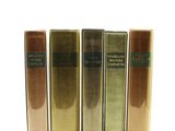 quatre livres sont alignés sur une surface blanche