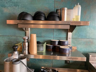 a metal shelf with pots and pans on top of it