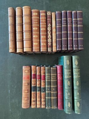 an assortment of old books are lined up on a table