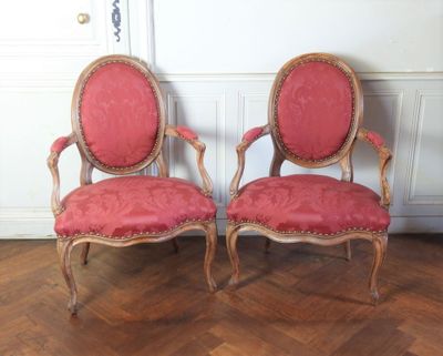 deux chaises rouges placées l'une à côté de l'autre sur un parquet