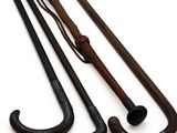 two old canes and a cane holder on a white surface