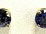 a pair of blue sapphire earrings on a white surface
