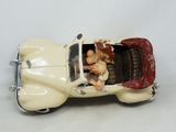 a figurine of a man and a woman in a car