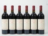 six bouteilles de vin rouge alignées sur une surface blanche