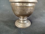 a silver bowl with a rope around it on a table