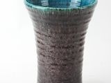 a close up of a vase on a white surface