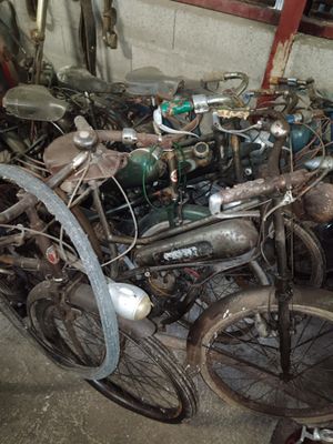 a lot of old bikes that are sitting in a garage