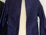 a blue jacket on a mannequin stand in a room