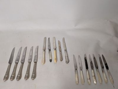 a lot of knives that are laying on a table