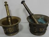 pair of antique brass mortar and pest grinds on a white surface