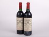 deux bouteilles de vin rouge posées l'une à côté de l'autre sur une surface blanche