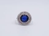 a close up of a blue sapphire and diamond ring on a white background
