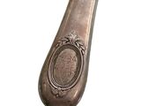 a silver spoon with a picture on it on a white background