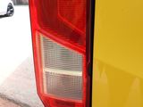 a close up of a yellow car with a red tail light