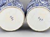 pair of blue and white vases sitting on top of a table