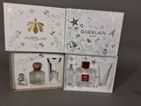 three boxed perfume bottles in a box on a table