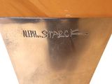 a silver vase that has writing on it