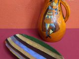 un vase et une assiette posés sur une table près d'un mur