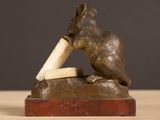 a statue of a bear holding a banana on top of a table