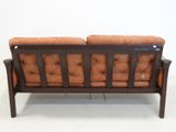 an image of a wooden couch with orange cushions