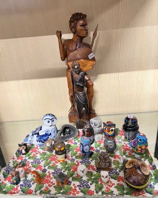 une statue représentant un homme tenant une guitare, posée sur une table aux côtés d'autres figurines