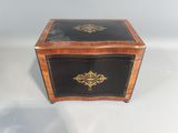 an antique wooden box with a black and gold decoration