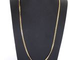 un collier à chaîne en or sur un présentoir à mannequin