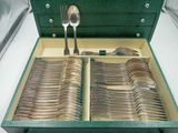 une boîte verte contenant des couverts, posée sur une table