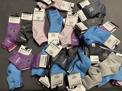 several pairs of women ' s socks with price tags on them on a table