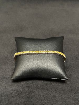a black pillow with a gold bracelet on it