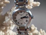 une montre en argent avec des chiffres romains sur le bracelet
