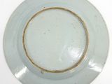 a white plate with a brown rim on a white table