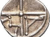 a silver coin with an image of a cross on it