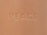 a close up of the word peace written on the side of a bottle