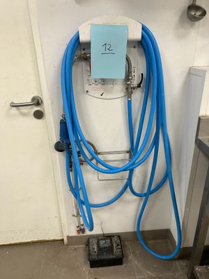 un tuyau bleu raccordé à un mur blanc