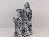 blue and white porcelain figurine of a woman holding a bird
