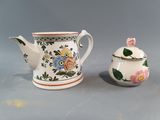 a small tea pot and a small tea pot on a table