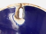 a blue and white bowl with a hole in it