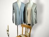 deux mannequins debout à côté d'une chaise et d'un vase de fleurs