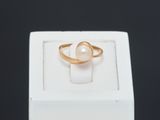 a close up of a gold ring with a pearl in it