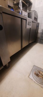 un sol sale dans une cuisine équipée d'appareils électroménagers en inox
