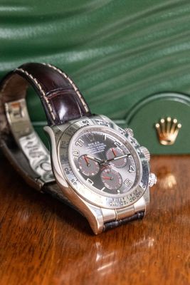 a watch sitting on a table next to a green purse