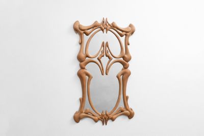 une image représentant un miroir en bois accroché à un mur